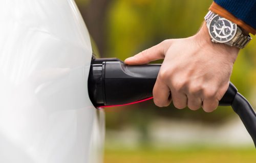 close-view-man-plugging-charger-into-electric-car-charging-port (1)