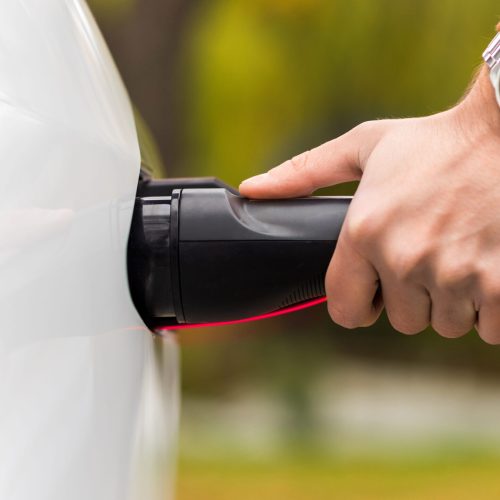 close-view-man-plugging-charger-into-electric-car-charging-port (1)