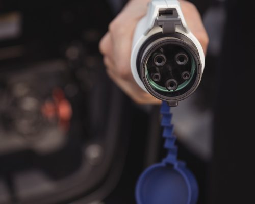 man-holding-car-charger-electric-vehicle-charging-station (1)